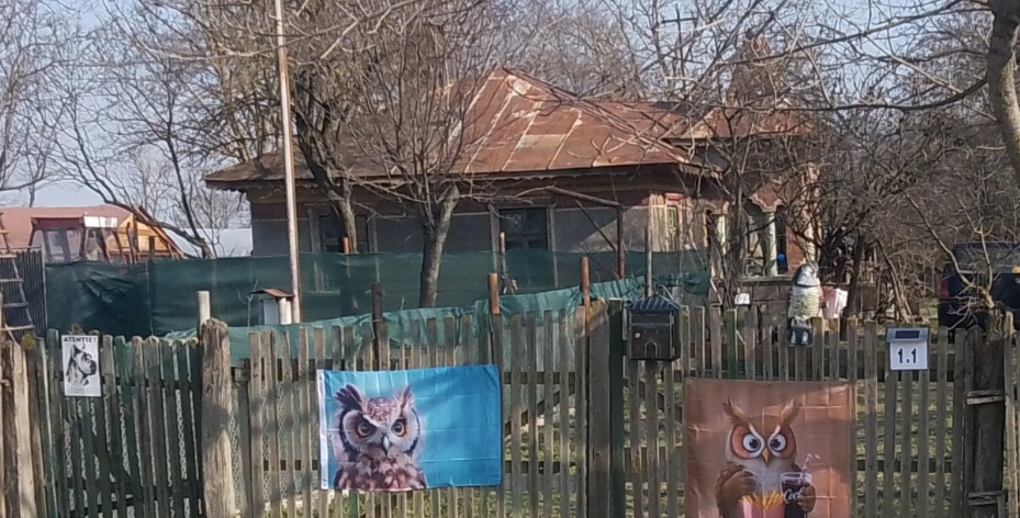 The wooden gate with two owl pictures and the kilometre 1.1 sign